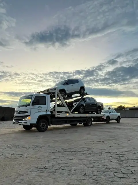 Caminhão com prancha carregada ao entardecer